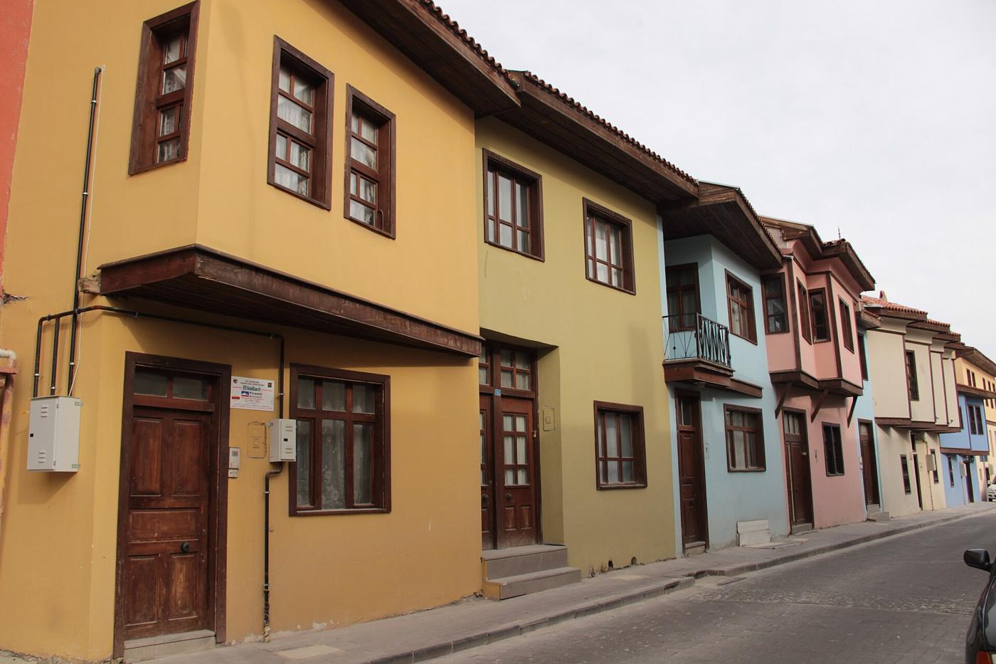 Uşak'ta restore edilmiş, sarı ve mavi boyalı tarihî evlerin sıralandığı sokak